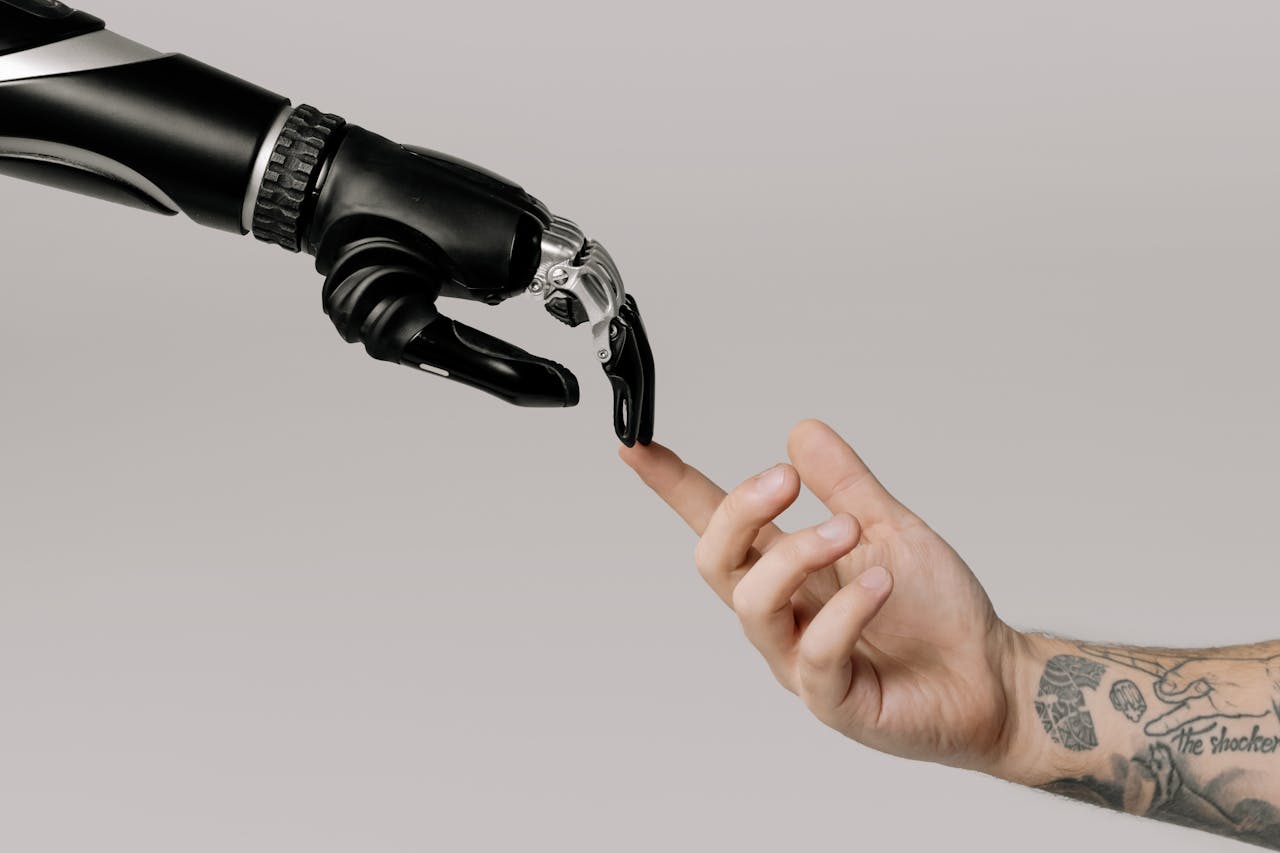 Mastering the First Impression: Your intriguing post title goes here A human hand with tattoos reaching out to a robotic hand on a white background.
